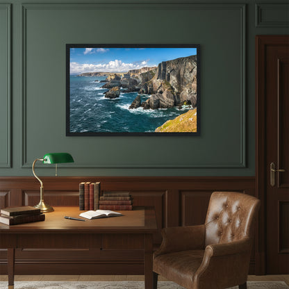 Heritage-style study with dark green walls and vintage writing desk, Mizen Head artwork in black frame above antique brass lamp and leather armchair.