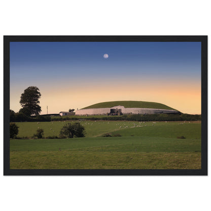 Newgrange framed print: Black frame variant hung in a modern collector’s loft with stone wall texture, spot lighting, and Irish landscape photography nearby — refined, luxurious interior.