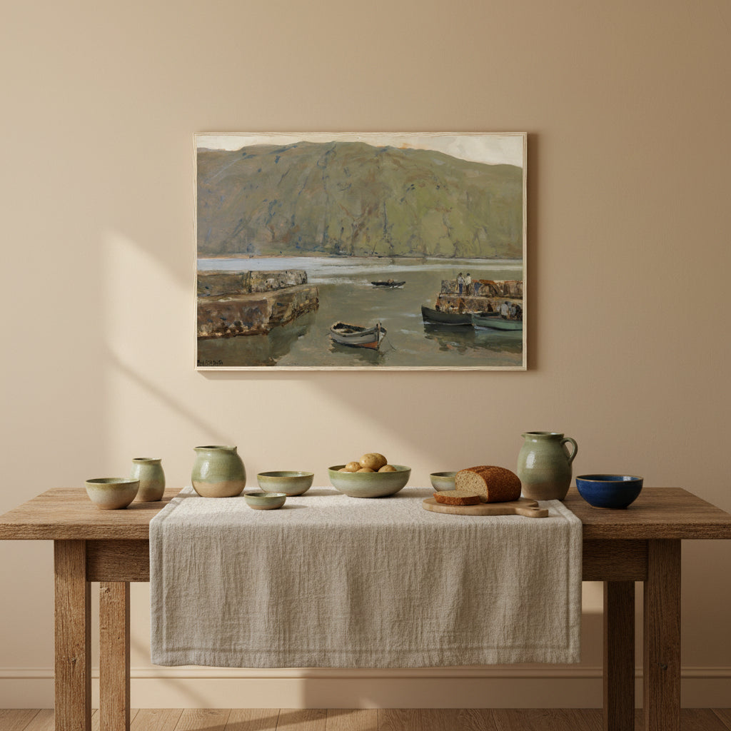 The Harbour, Leenane by James Humbert Craig framed in natural wood, 70×100 cm, premium Irish landscape art print. Natural oak frame above a rustic farmhouse dining table; Connemara aesthetic; textured linen, pottery, calm daylight.